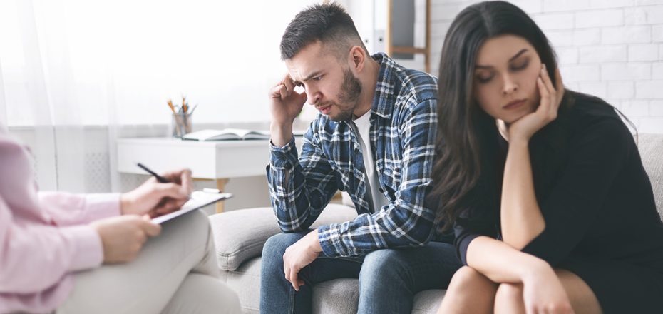 Divorce. Stressed couple sitting separately at family counselor office, empty space